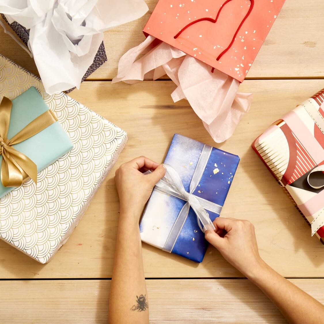 Hands tying a ribbon on a gift